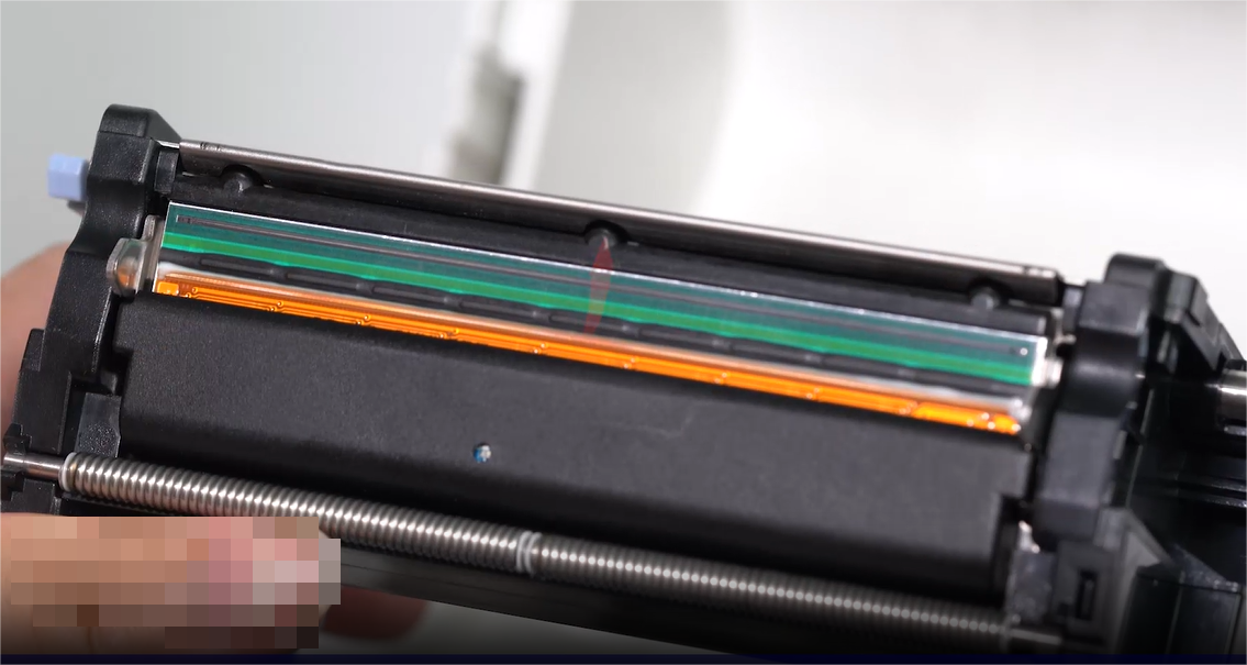 Sebuah close-up of a person carefully cleaning an electronic component with a swab.